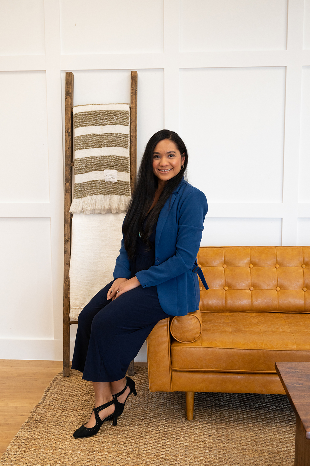 Psychologist Angelique sitting on a couch with a blue jacket